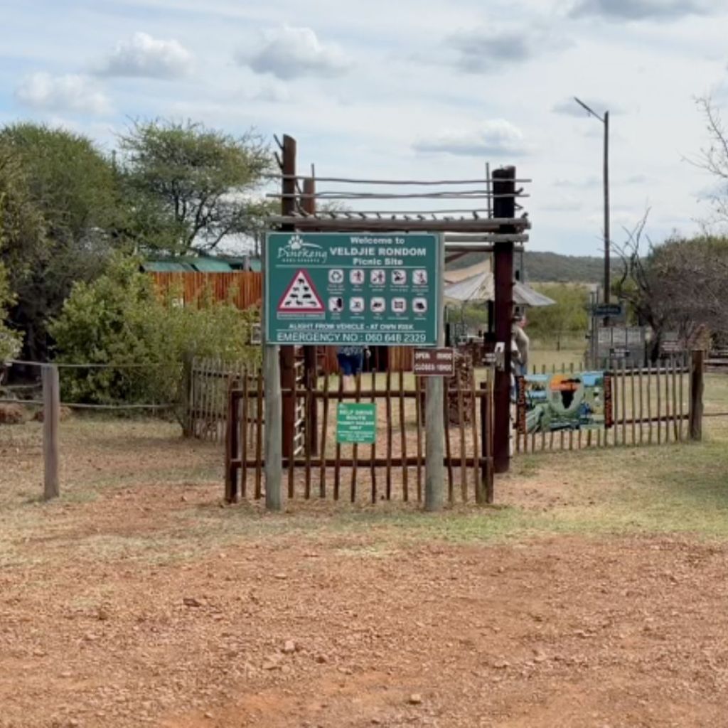 Entrance to the Veldjie Rondom Picnic Site in Dinokeng Game Reserve, featuring a welcome sign and safety information.